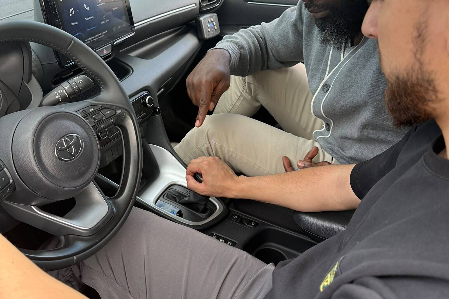 Un moniteur d'AB Conduite 94 montre le sélecteur de boîte automatique à un élève, dans la voiture de l'auto-école à Noiseau