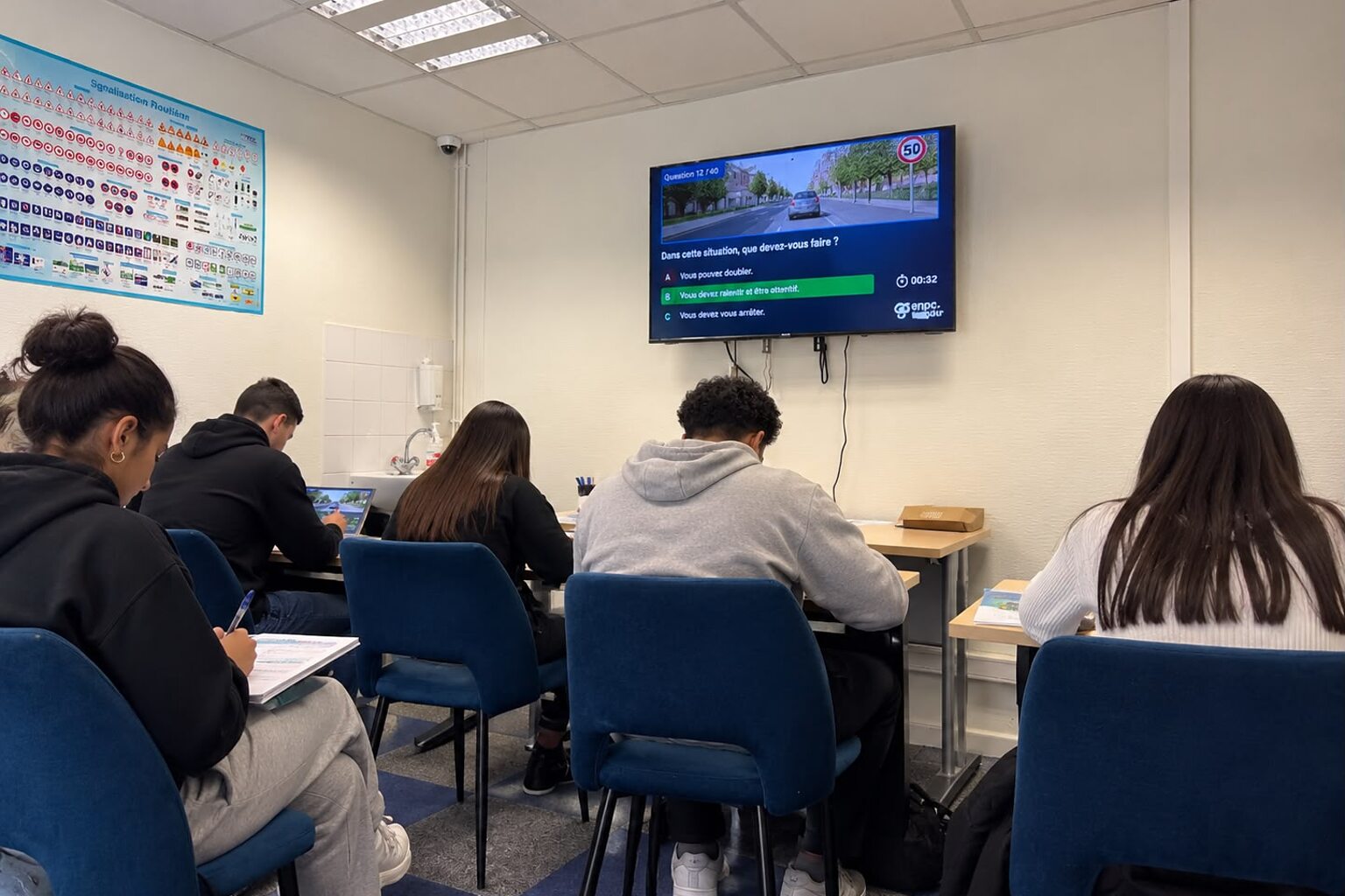 La salle de code d'AB Conduite 94 à Noiseau : des élèves en séance d'entraînement devant l'écran de questions du code