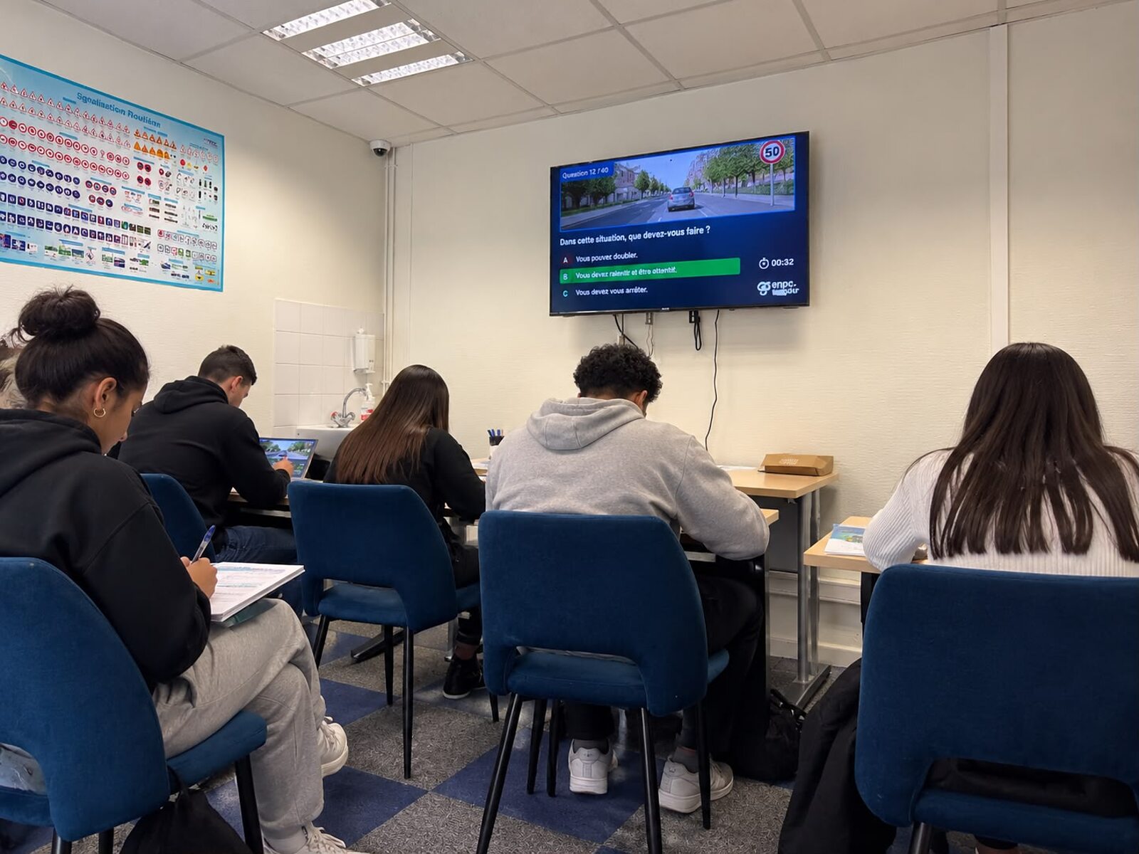 La salle de code d'AB Conduite 94 à Noiseau : des élèves en séance d'entraînement devant l'écran de questions du code